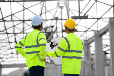 Construction worker discussing project details at building site.; Shutterstock ID 1808906971; purchase_order: -; job: -; client: -; other: -